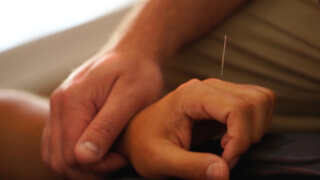 Private acupuncture treatment with needle in hand